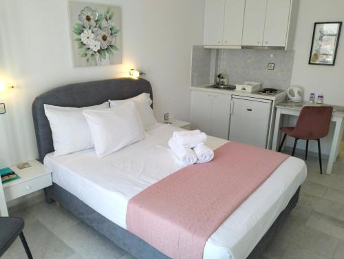a bedroom with a bed with two towels on it at Nostos Studios at Saint George beach Agios Georgios Chora Naxos town in Naxos Chora