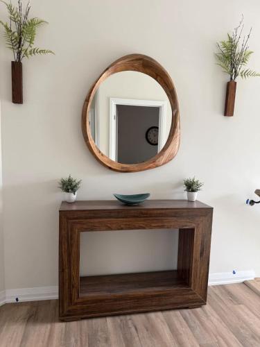 a wooden table with a mirror on a wall at The Evergreen Escape- Games Nature Near Muskoka in Severn