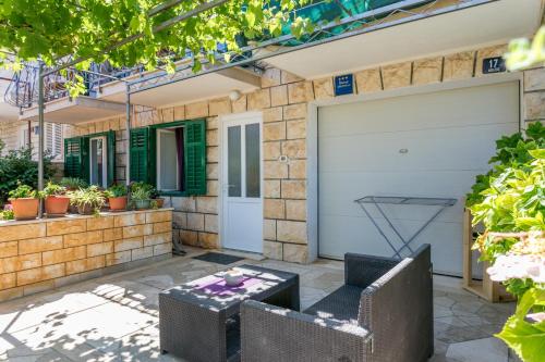 a garage with two chairs and a table on a patio at Apartments and rooms with parking space Supetar, Brac - 5658 in Supetar
