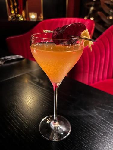 a drink in a glass sitting on a table at Sofitel Queenstown Hotel & Spa in Queenstown