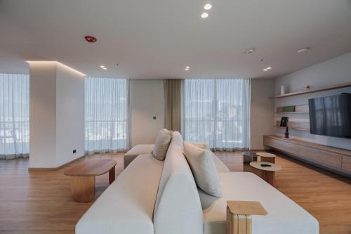 a living room with a white couch and a tv at Seissta Medellín in Medellín