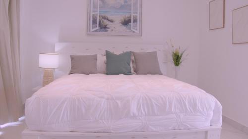 a white bed with a white comforter and pillows at Hotel Soficu Green Village 
