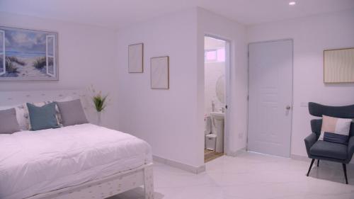 a white bedroom with a bed and a chair at Hotel Soficu Green Village 