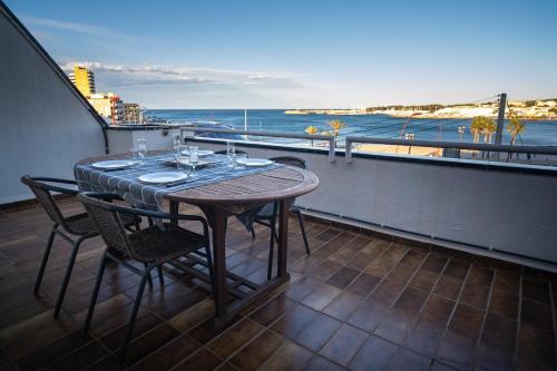 a table and chairs on a balcony with a view of the ocean at Pis a primera línia de mar in L'Escala