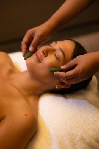 a woman laying on a bed getting her hair washed at Sofitel Queenstown Hotel & Spa in Queenstown