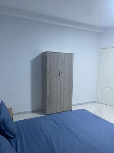a wooden cabinet in a bedroom with a bed at Appartement s2 avec garage in Radès