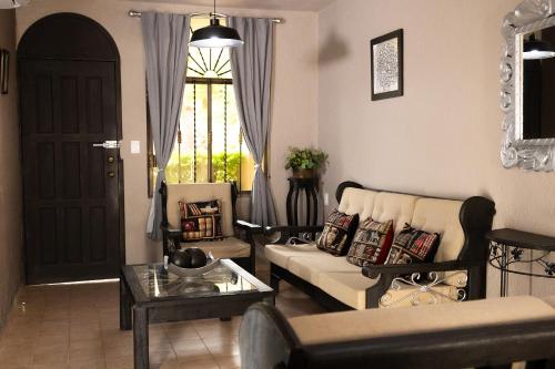 a living room with a couch and chairs and a window at COLONIAL Suites in Ciudad Valles