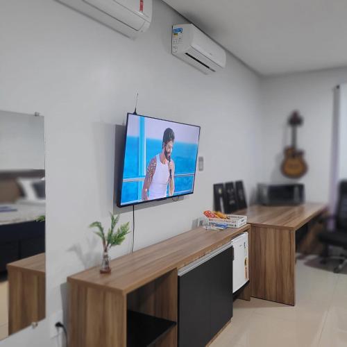 a flat screen tv hanging on a wall in a living room at Pousada Loft Marabá in Marabá