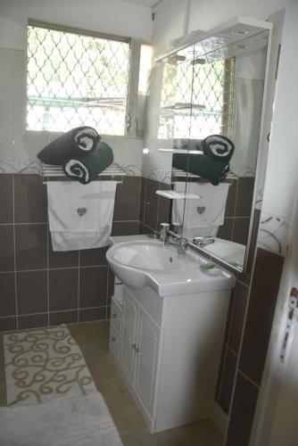 a bathroom with a sink and a mirror at Gite d'Arles "Villa Doudou" in Le Moule