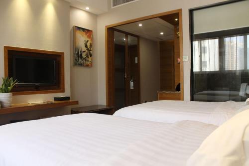 a bedroom with two beds and a flat screen tv at Holiday Inn Express Xiamen Lushan -Shopping Center by IHG in Xiamen