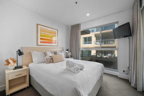 una camera da letto con un letto grande e una finestra di Belle Escapes - Beachside Apartment in Glenelg a Glenelg