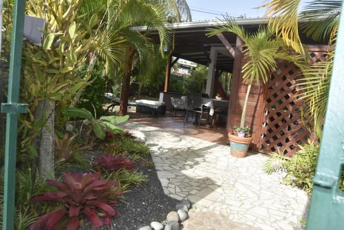 a garden with a patio with palm trees at Gite d'Arles "Villa Doudou" in Le Moule