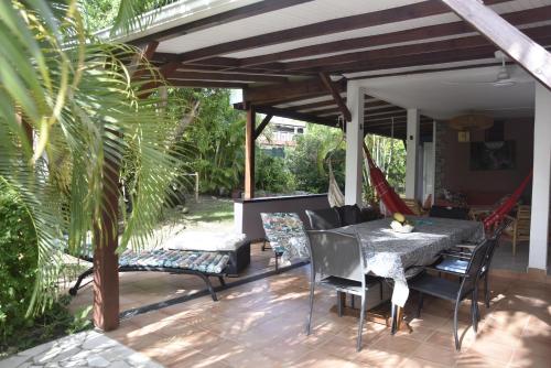 a patio with a table and chairs under a pergola at Gite d'Arles "Villa Doudou" in Le Moule