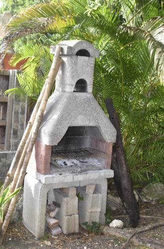 a stone pizza oven with a stick on top at Gite d'Arles "Villa Doudou" in Le Moule