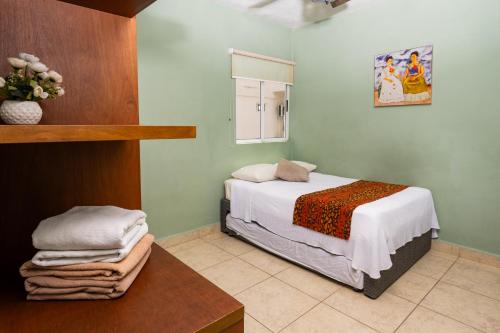 a bedroom with a bed and a table and a window at UNICO Y AGRADABLE DTO EN ZONA CENTRO PARA 6 PAX in Cancún