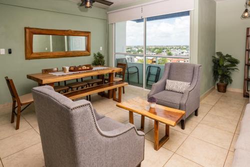 a living room with a table and two chairs and a table and a window at UNICO Y AGRADABLE DTO EN ZONA CENTRO PARA 6 PAX in Cancún