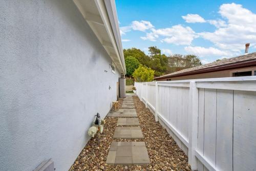 a side walk next to a white fence at Yellow Door Beach House close to Moonlight Beach and LEGO Land in Encinitas