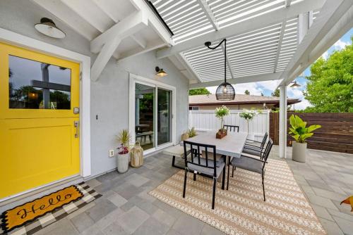 a yellow door on a patio with a table and chairs at Yellow Door Beach House close to Moonlight Beach and LEGO Land in Encinitas