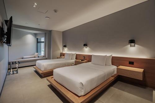 a hotel room with two beds and a couch at Seissta Medellín in Medellín