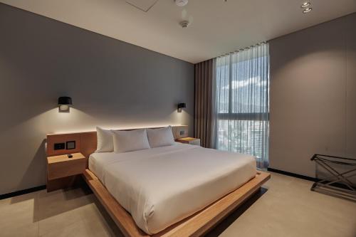 a bedroom with a large bed and a large window at Seissta Medellín in Medellín