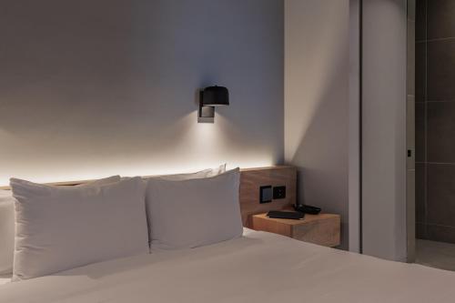 a bedroom with a bed with white pillows and a lamp at Seissta Medellín in Medellín