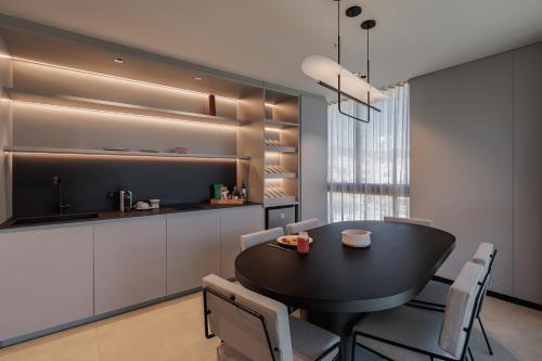 a kitchen and dining room with a black table and chairs at Seissta Medellín in Medellín