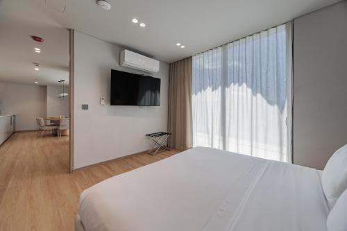 a bedroom with a white bed and a large window at Seissta Medellín in Medellín