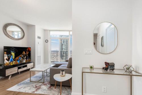 ミシサガにあるLavish 2BR 2Bath Condo Steps to Square One Mallのソファとテレビのあるリビングルーム