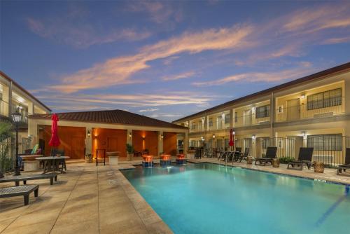 a pool at a hotel with tables and chairs at Best Western San Isidro Inn in Laredo