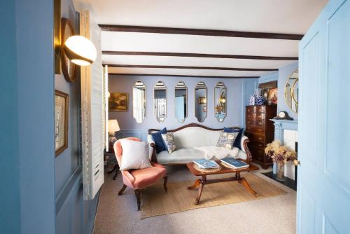 a living room with a couch and chairs and mirrors at One Church Square in Rye