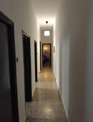 a hallway with white walls and a long hallway with black doors at Appartement Centre-ville in Tetouan