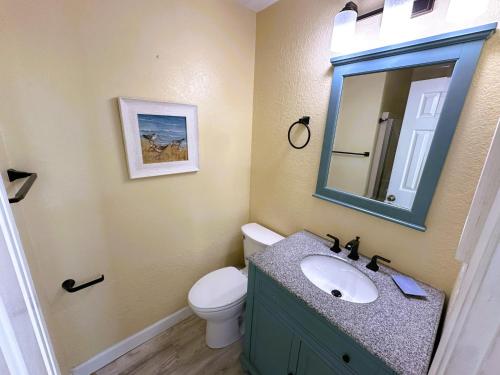 a bathroom with a sink and a toilet and a mirror at KH5205- Katmandunes in Kitty Hawk