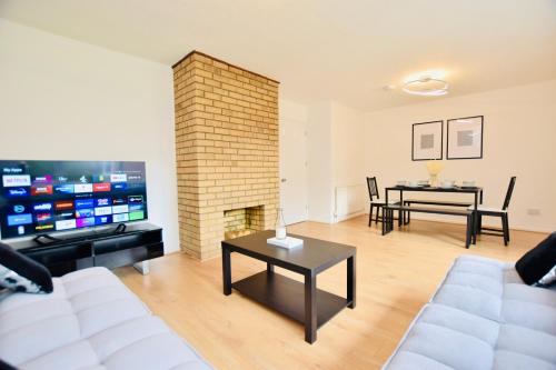 a living room with a white couch and a fireplace at Spacious Central Oxford Detached Home in Oxford
