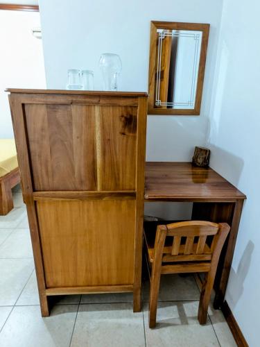 a wooden desk with a chair and a mirror at Hostal Macaw in Guayaquil