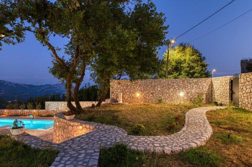 a garden with a stone path leading to a swimming pool at Villa 53 in Lapčići