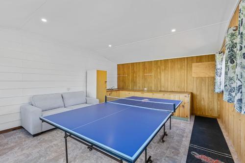 a ping pong table in a room with a couch at Winnies on Sunpatch in Tomakin
