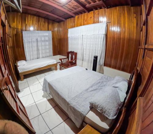a bedroom with a bed and a chair in it at CASA DE CAMPO JACUZZI MONTAÑA NATURALEZA Leso in San Lorenzo