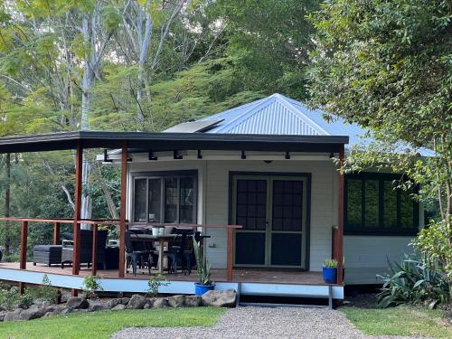 a small cottage with a porch and a table at Brightside Holidays in Landsborough