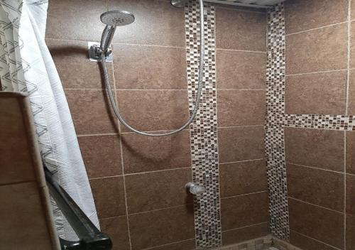 a shower in a bathroom with a tiled shower at VIGILANTE INN Invincible Quarters in Tombstone