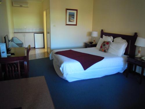 a hotel room with a large bed and a desk at Tree Top Walk Motel in Walpole