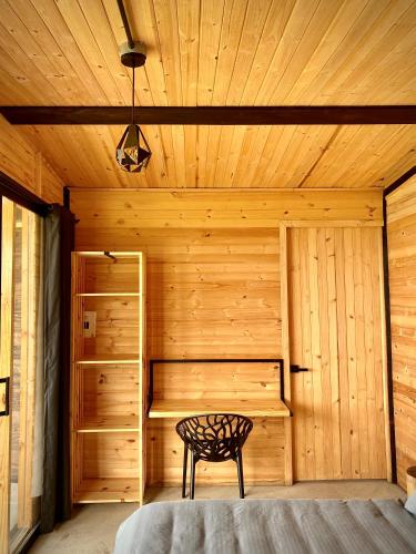 a wooden room with a bed and a chair in it at Taikú Ecolodge in Pacho