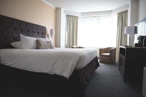 a hotel room with a large bed and a window at Taormina Hotel y Casino in San José