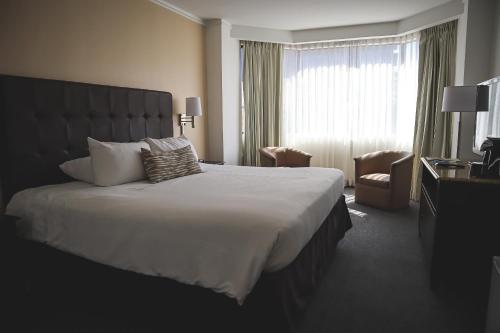 a hotel room with a large bed and a window at Taormina Hotel y Casino in San José