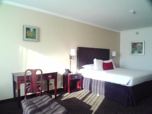 a hotel room with a bed and a chair at Taormina Hotel y Casino in San José