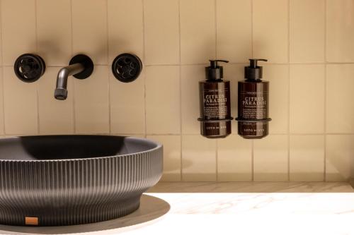a bathroom with a sink and two bottles of soap at The Host Medellin in Medellín