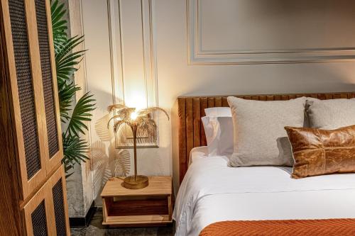 a bedroom with a bed and a lamp on a table at The Host Medellin Adults Only in Medellín
