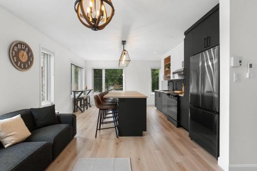 a kitchen and living room with a couch and a table at Le Madison Charmant et Unique 3 bedrooms in Quebec City