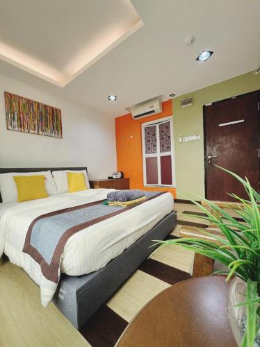 Un dormitorio con una cama grande con almohadas amarillas. en Chendering Inn, en Kuala Terengganu