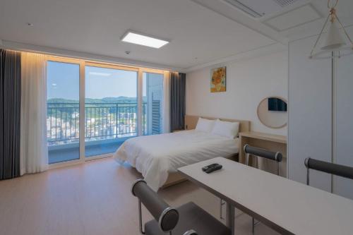 a hotel room with a bed and a large window at The Ocean by Owners hotel Yangyang in Yangyang