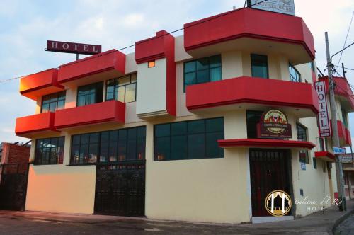 a hotel with a red and white building at Balcones del Río Hotel in Latacunga